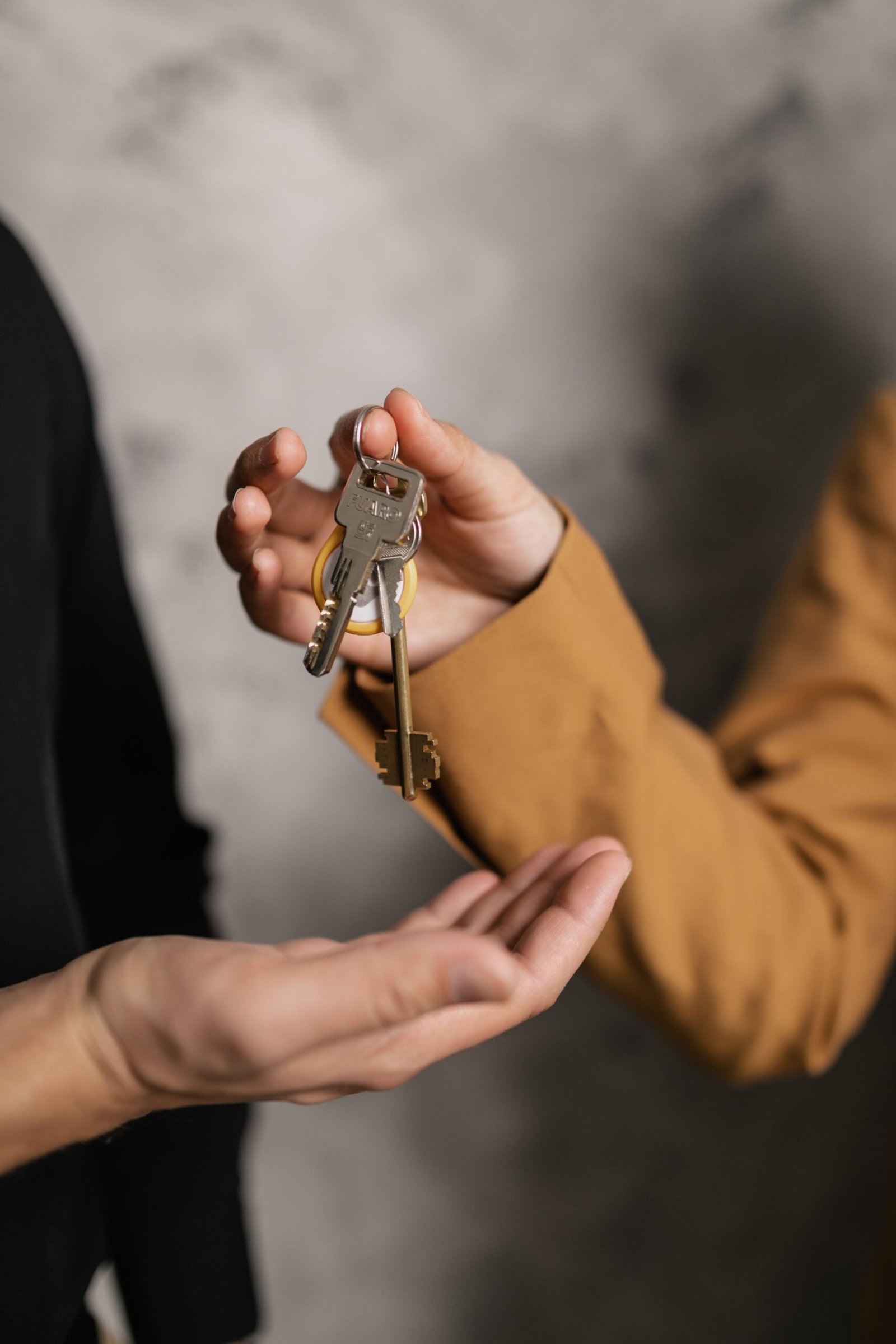 Hands exchanging keys for a rental property