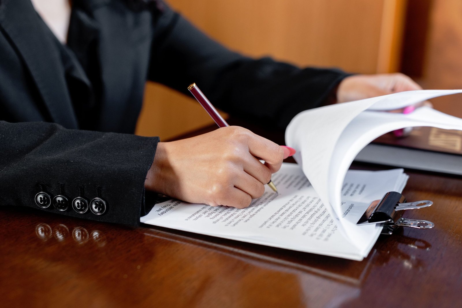 Person signing legal documents at a desk