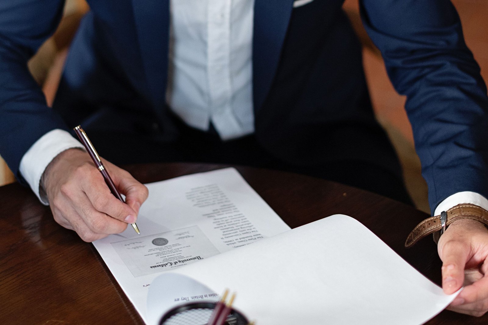 Person signing legal documents at a desk