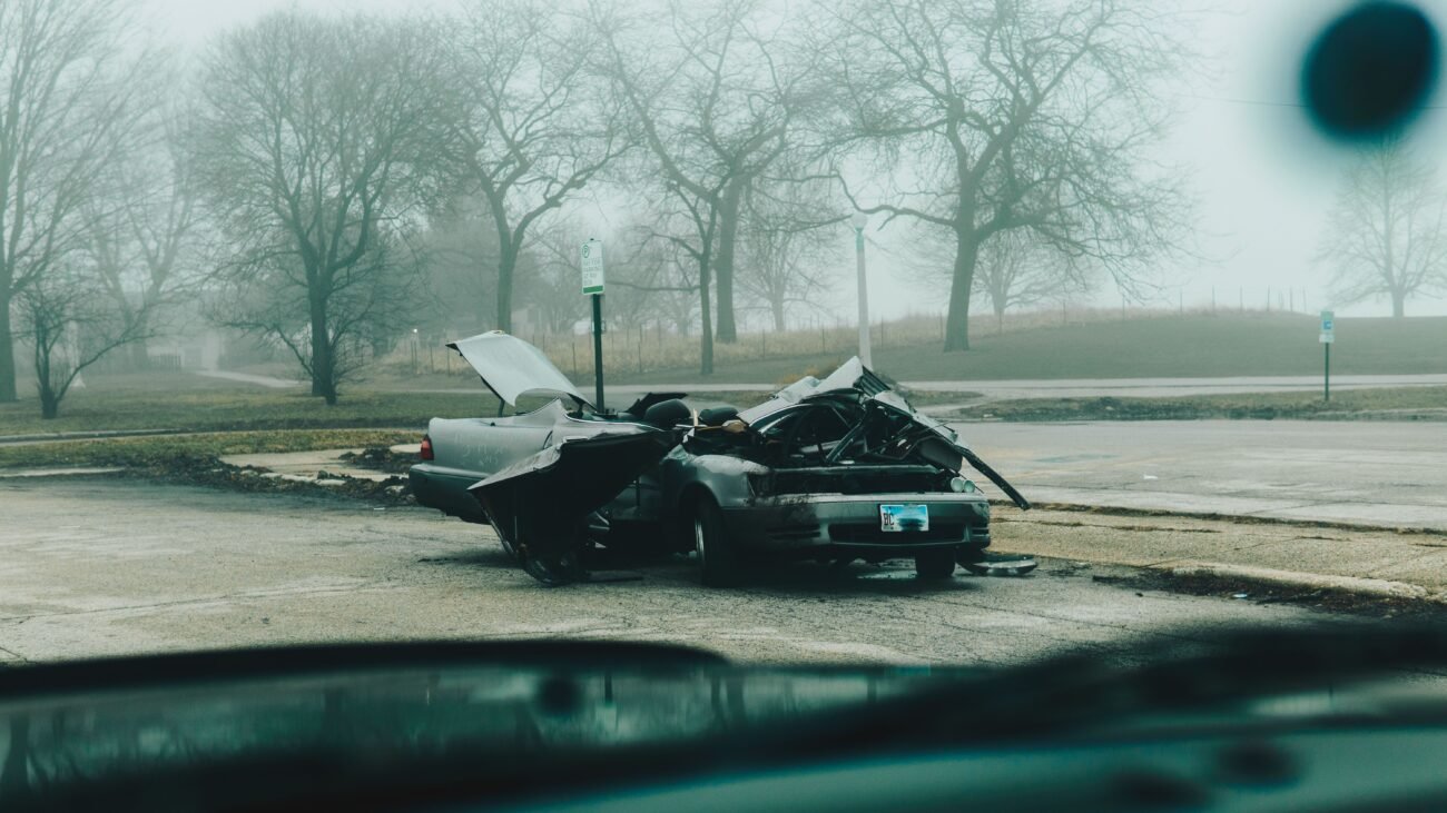 Severely damaged car on a quiet street, illustrating the aftermath of a hit-and-run collision