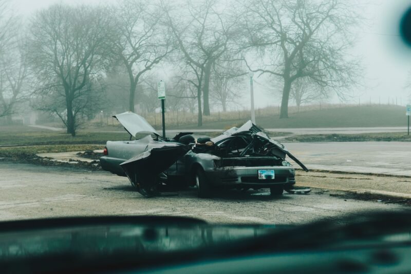 Severely damaged car on a quiet street, illustrating the aftermath of a hit-and-run collision