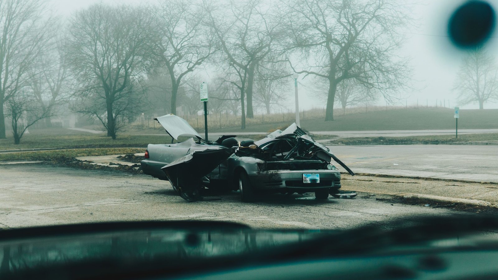 Severely damaged car on a quiet street, illustrating the aftermath of a hit-and-run collision