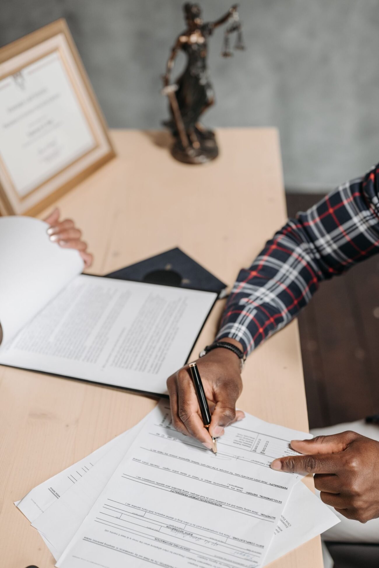 Hands signing official documents at a desk, illustrating power of attorney paperwork